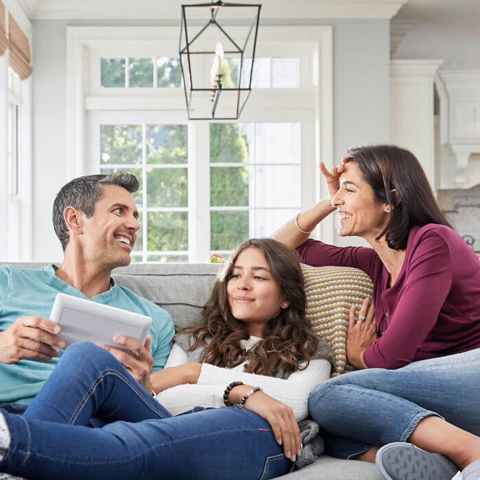 mother and father smiling with daughter at home