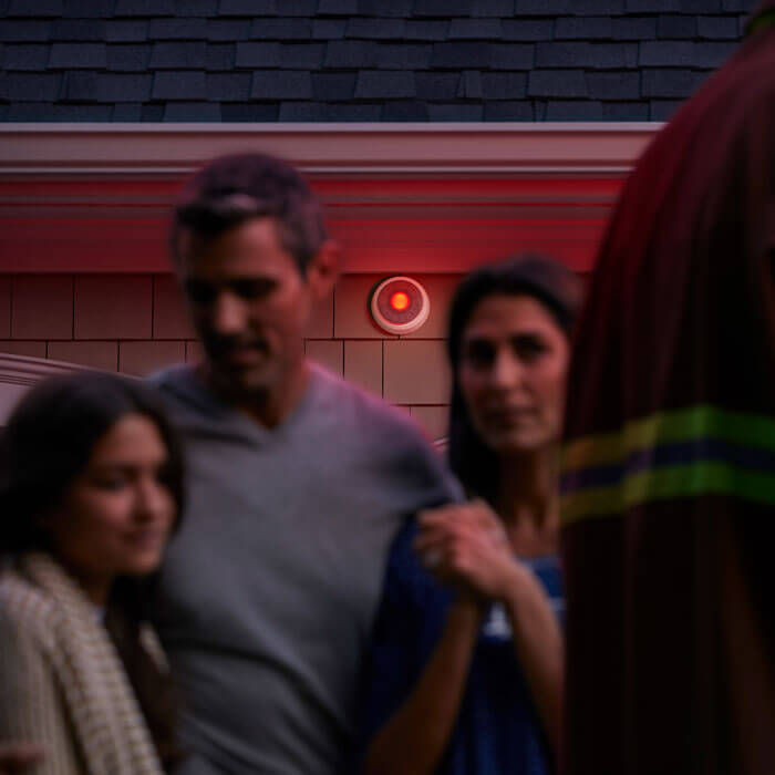 family outside of home with fireman