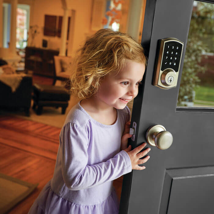little girl standing by front door with keypad lock