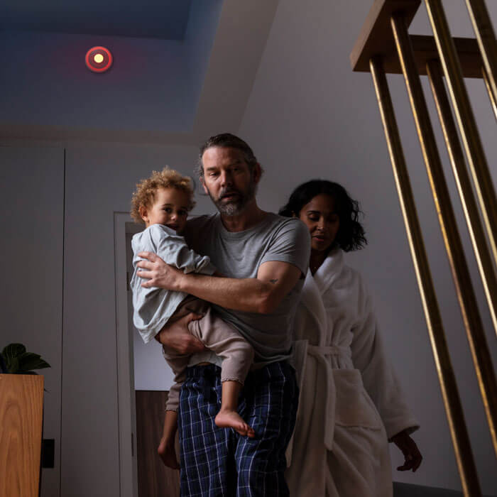 family heading downstairs at night while fire alarm goes off