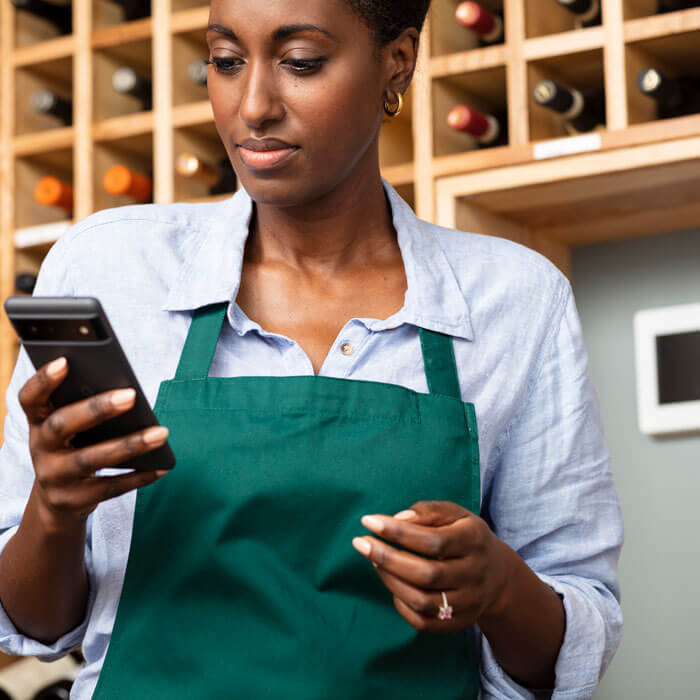 woman at work using phone with security panel on wall